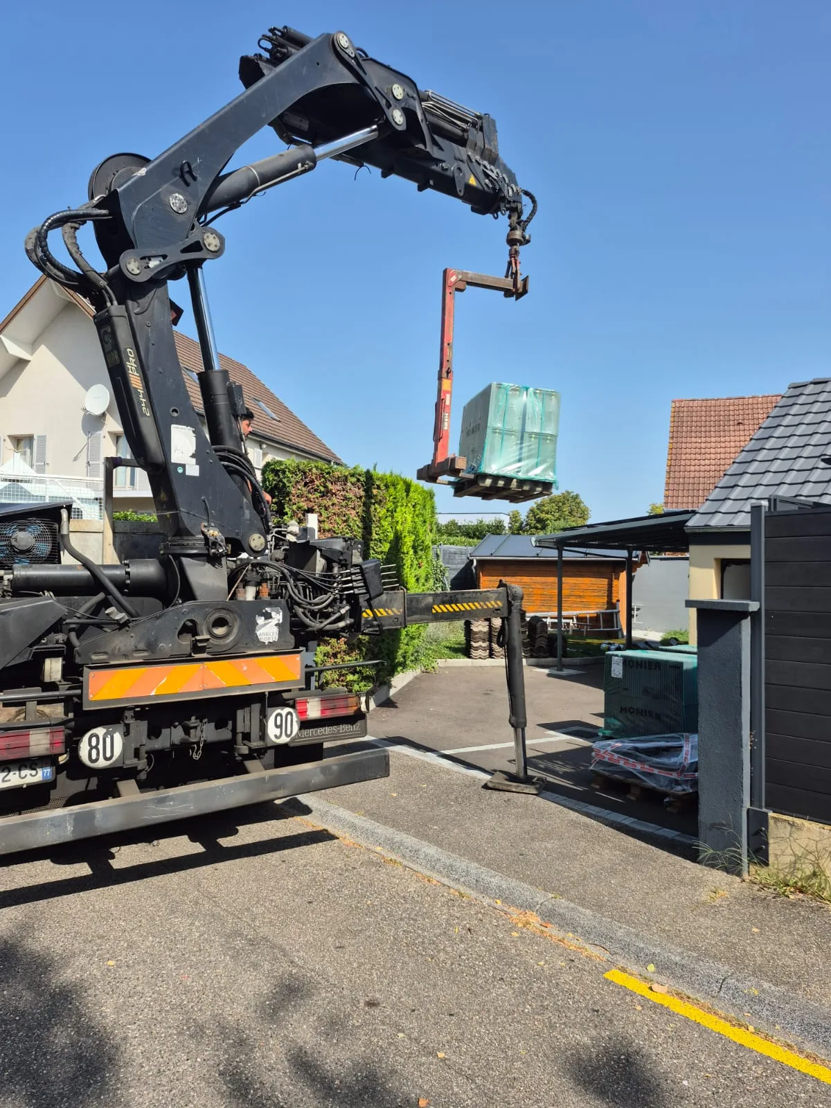 Livraison de tuiles par camion-grue sur un chantier SCM82 — logistique professionnelle