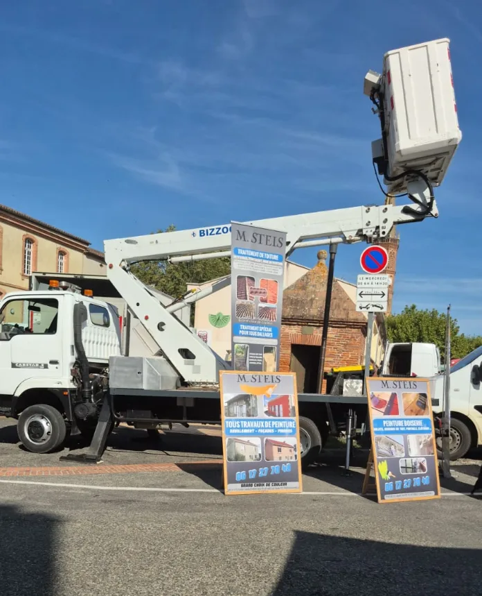 Stand SCM82 sur un marché du Tarn-et-Garonne — camion nacelle 14 m et panneaux de présentation des travaux de toiture et de peinture